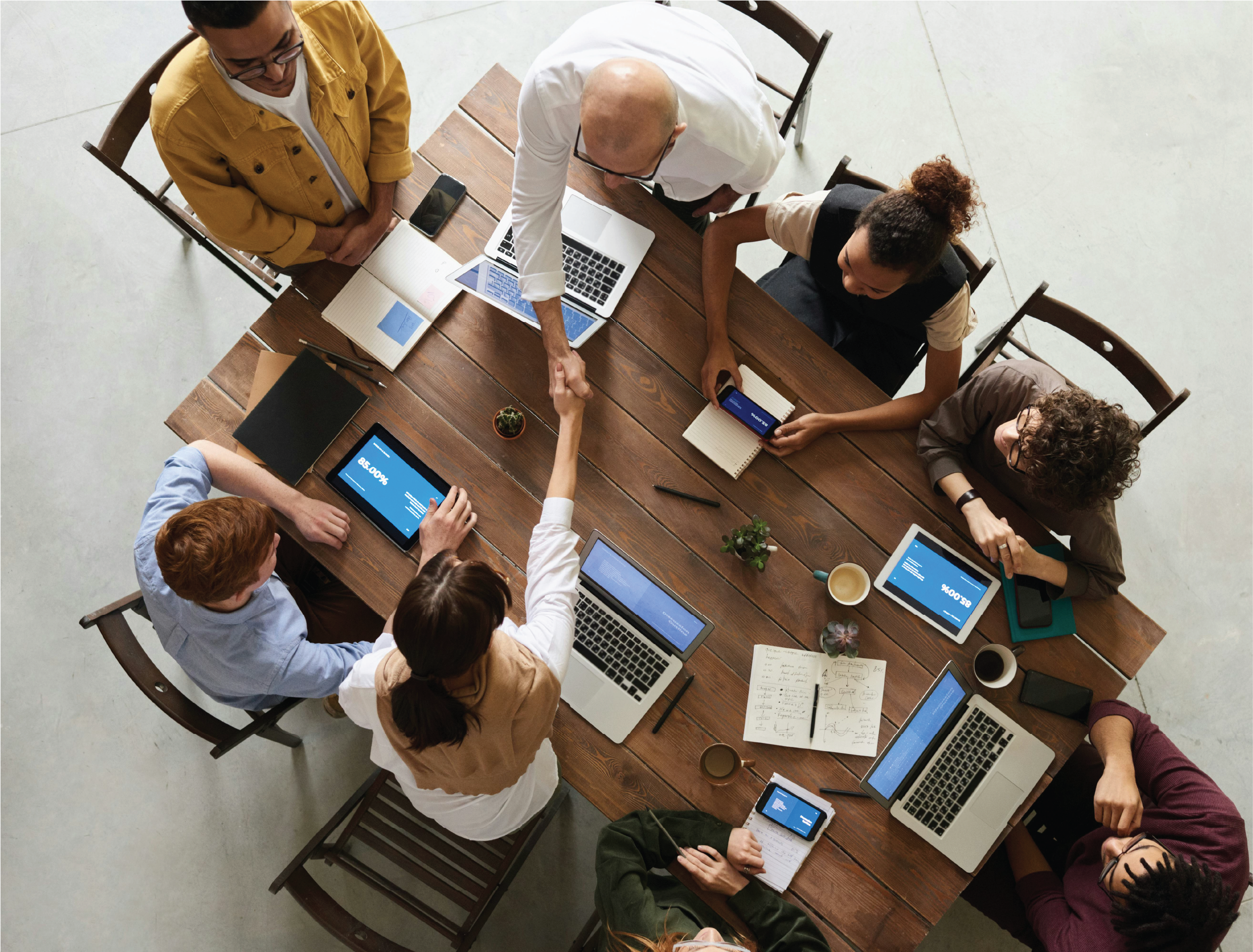 International collaboration meeting with laptops and documents on a wooden table